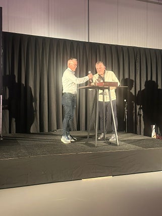 twee mannen op het podium in witte overhemden