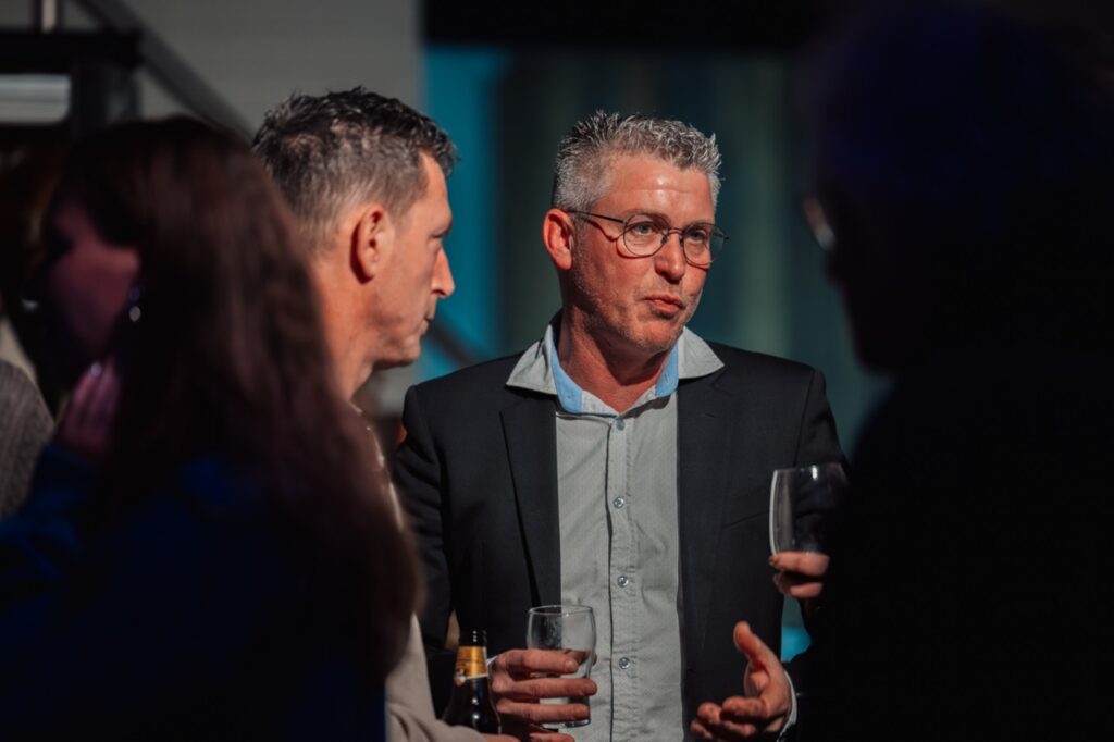 man met groen overhemd en bril